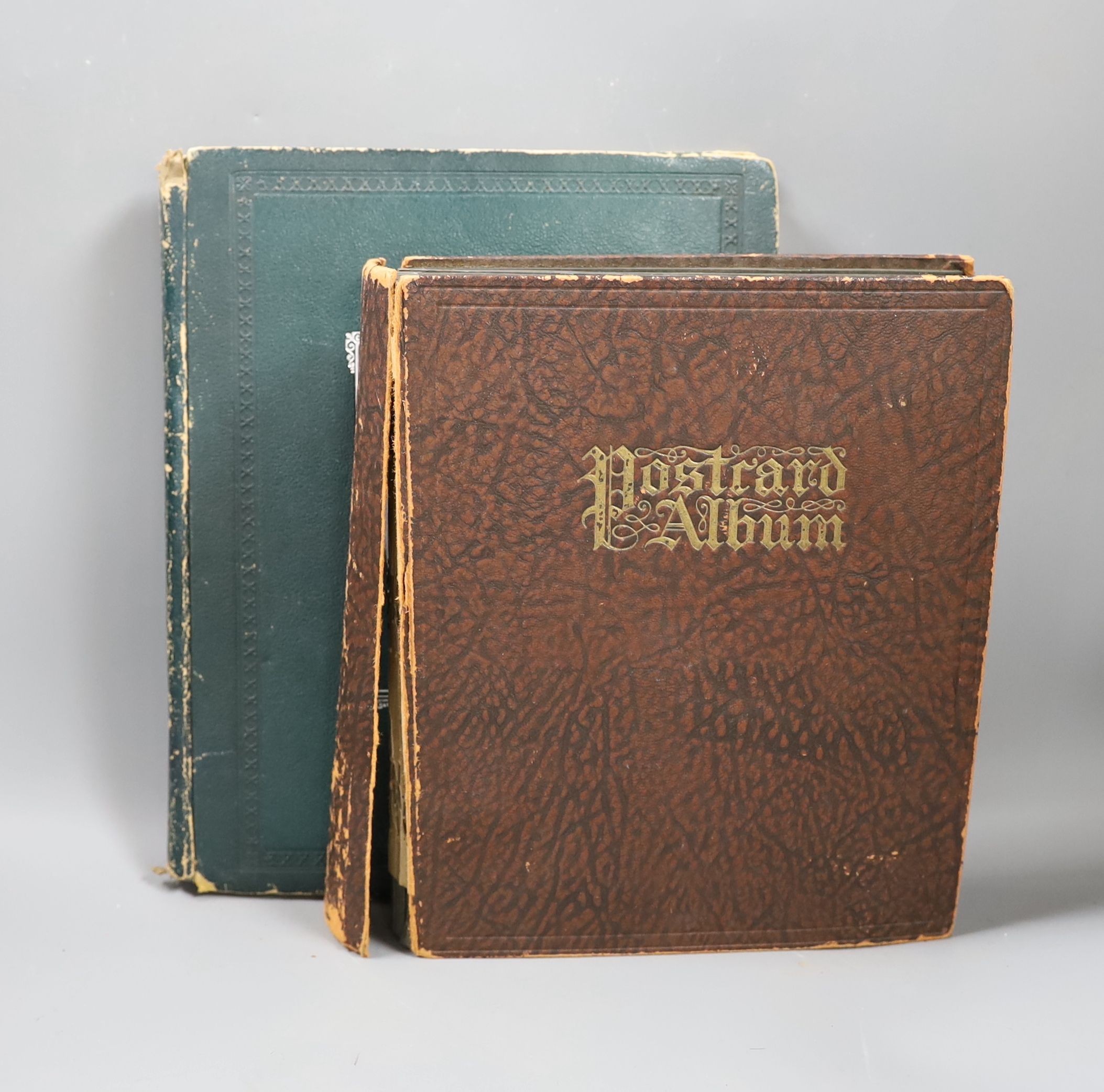 An Edwardian green postcard album, mounted with 68 risqué cards and a brown album mounted with Edwardian, George V and later, mainly topographical cards (2)